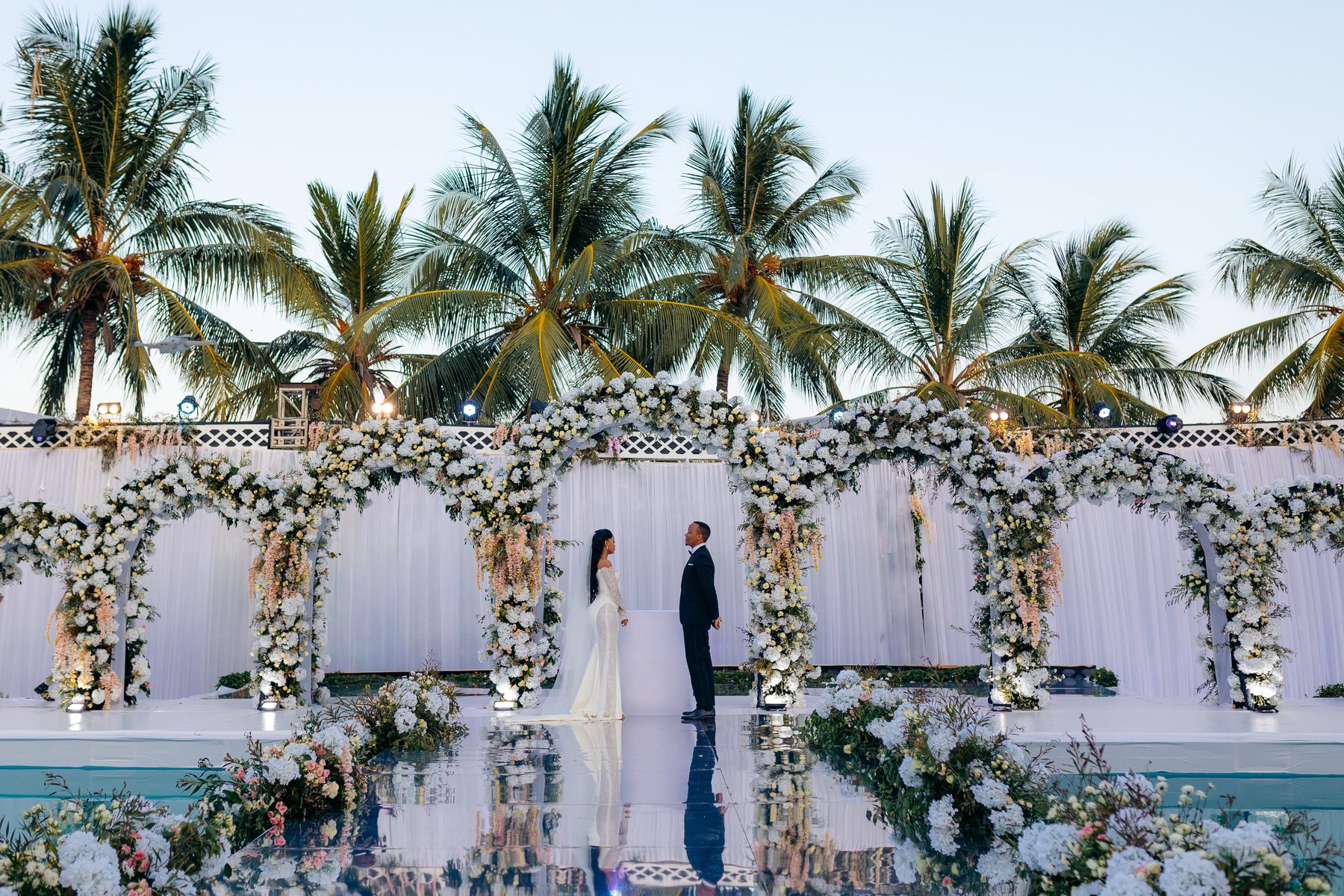 Ali & Dr. Lucy wedding in Tanga, Tanzania, by Kevins Events — the couple at the floral ceremony arch
