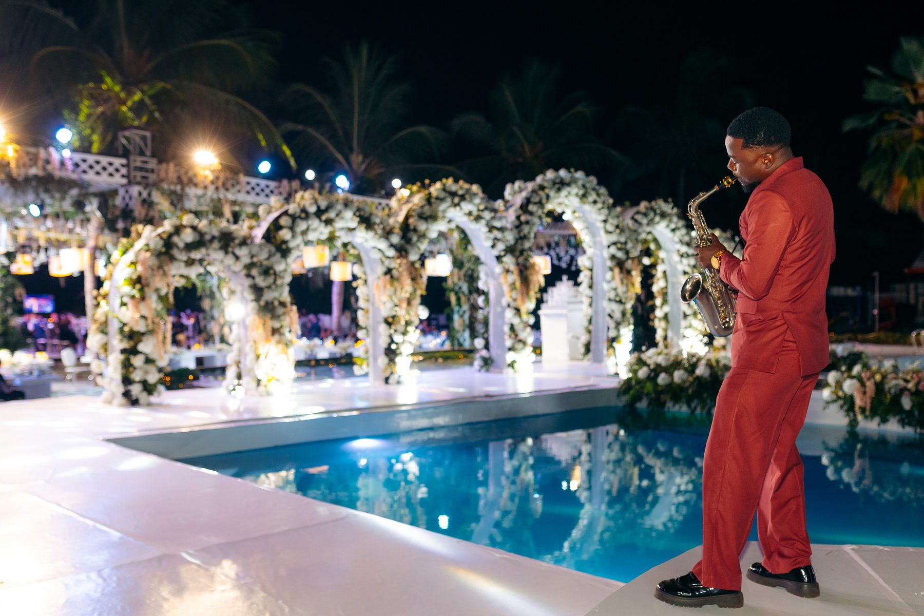 Ali & Dr. Lucy wedding in Tanga, Tanzania, by Kevins Events — poolside performance before the floral arches