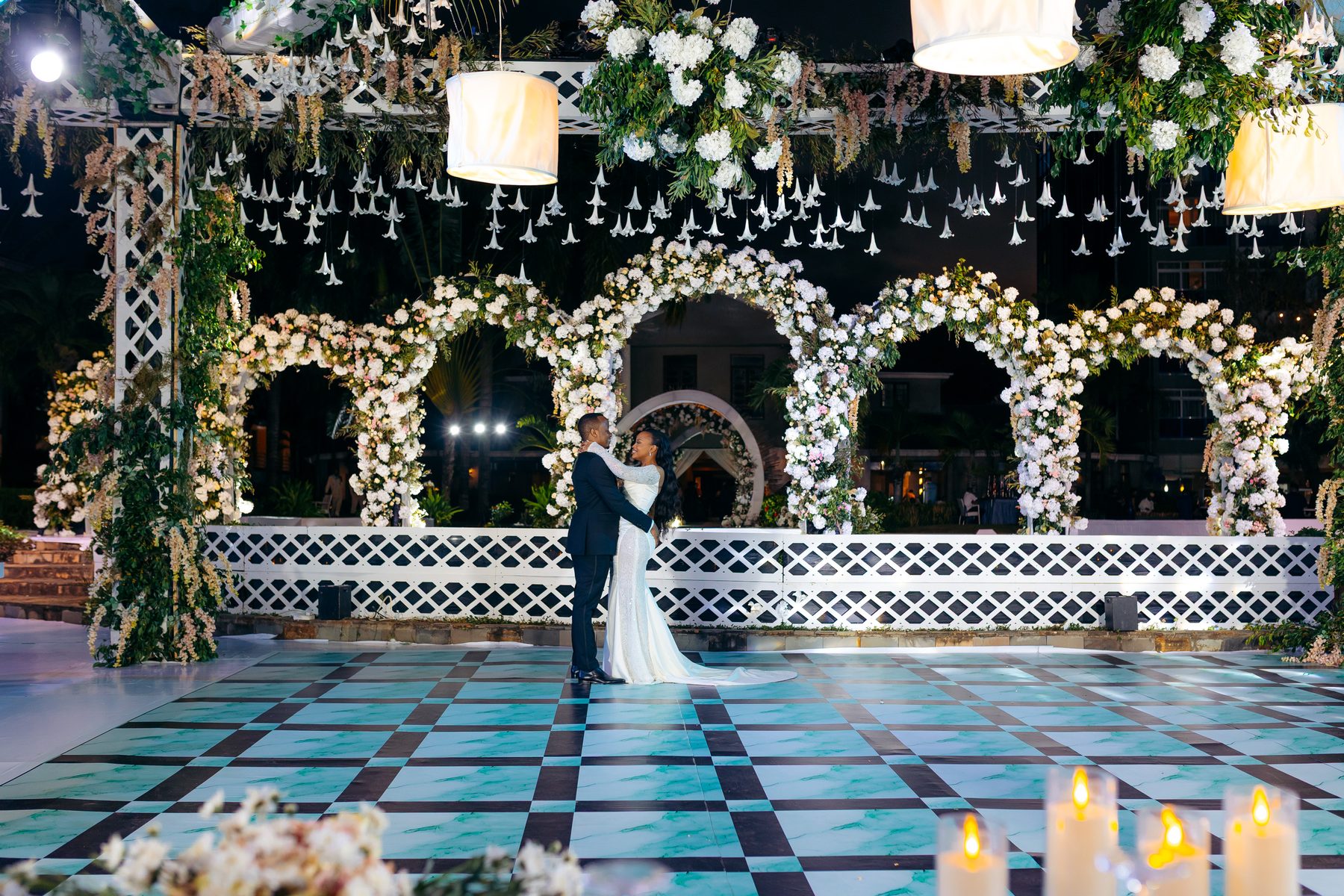 Ali & Dr. Lucy wedding in Tanga, Tanzania, by Kevins Events — the couple embracing on the checkerboard dance floor