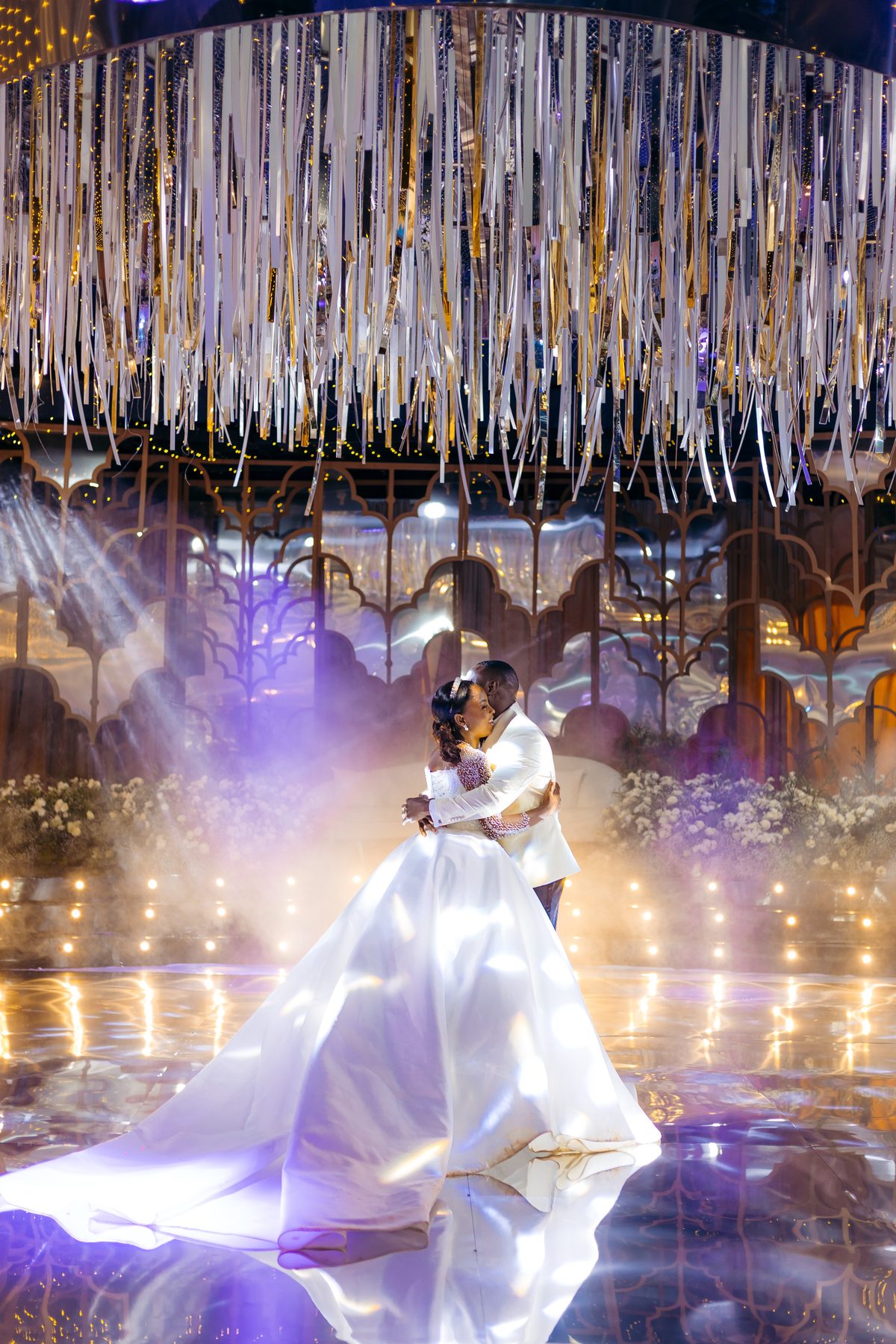 Jordan & Doria wedding at Serena Hotel, Dar es Salaam, by Kevins Events — the couple embracing on the mirrored floor