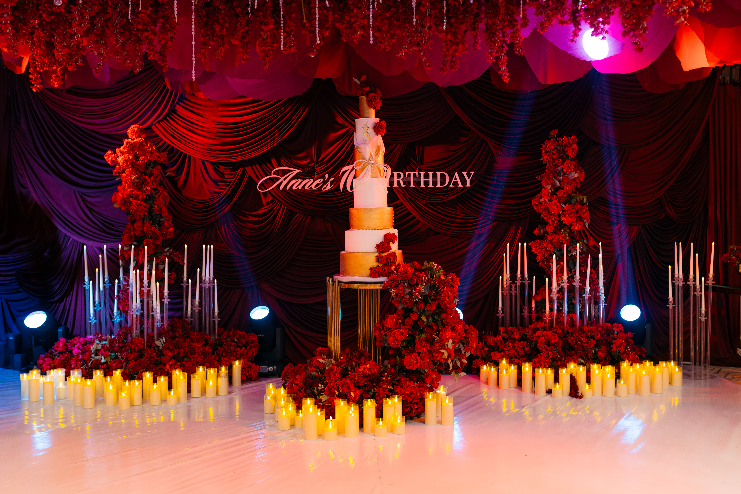 Five-tier birthday cake surrounded by red roses and candles — Kevins Events