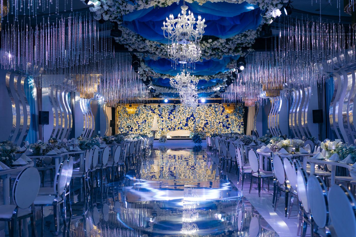 Blue wedding ballroom with crystal ceiling installation and mirror floor — luxury wedding design Tanzania