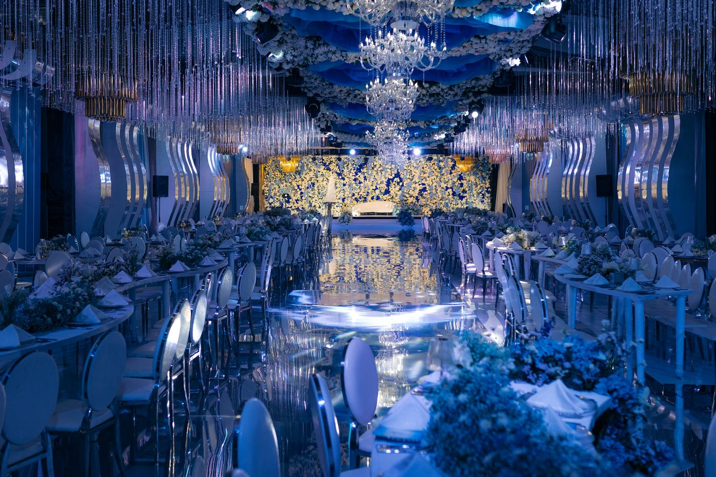 Blue wedding mirror aisle with floral arrangements and crystal chandeliers — Kevins Events