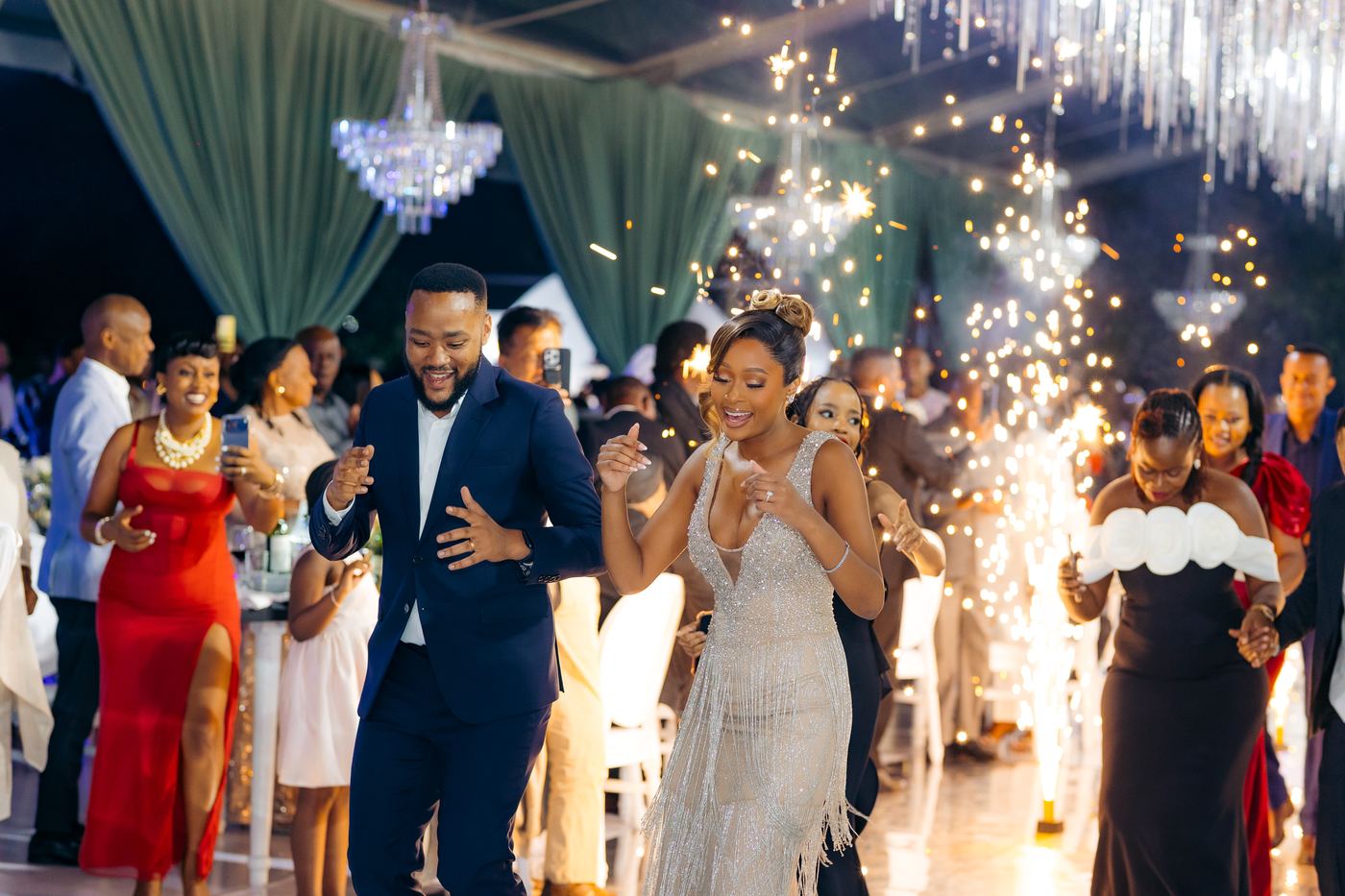 Wedding reception couple entrance with sparklers and guests celebrating — Kevins Events Dar es Salaam